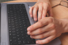 Fotografia dłoni na klawiaturze komputerowej