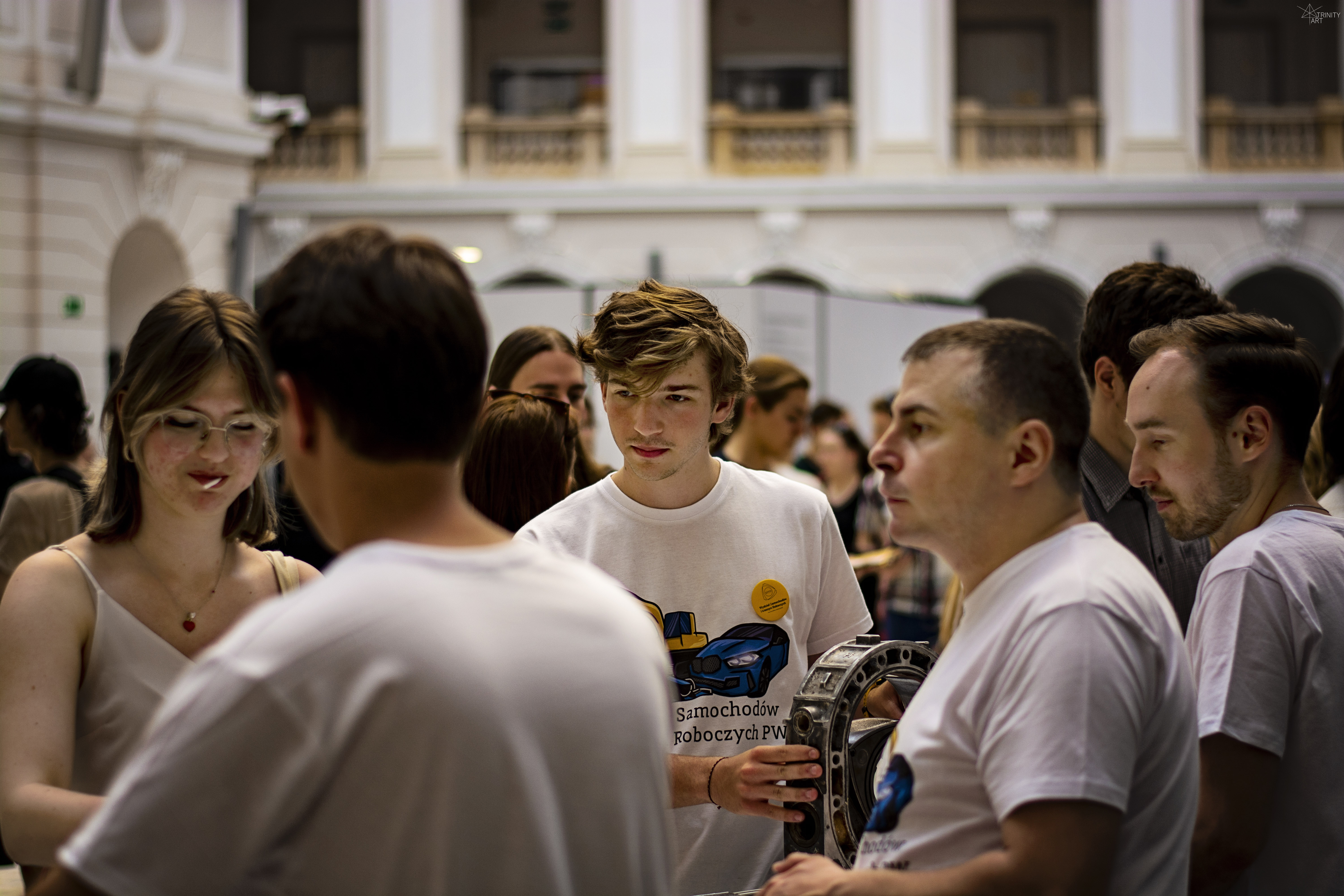 Grupa studentów rozmawiająca na auli Politechniki Warszawskiej.