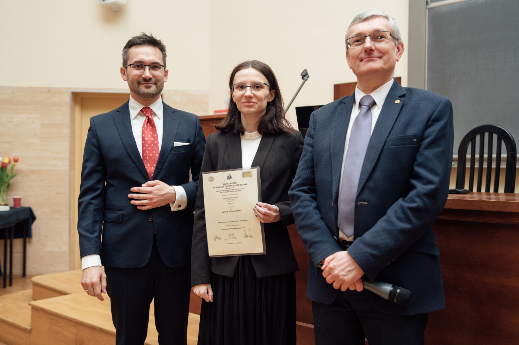 Studentka zwyciężczyni konkursu, odbierająca dyplom z rąk władz wydziału.