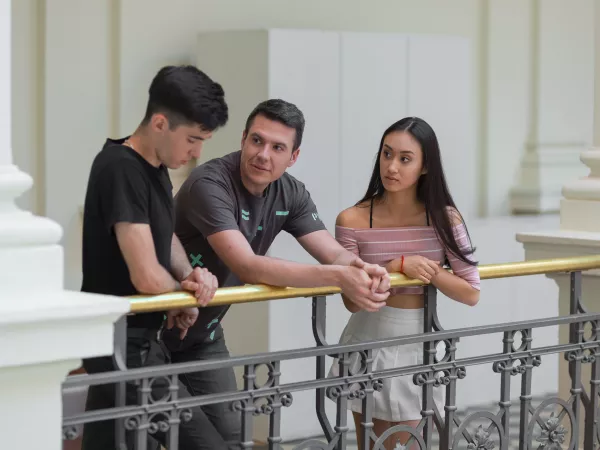 Three young people leaning on the railing