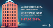 Po lewej stronie wysoki czerwony budynek, po prawej napisy "Akcja kwaterunkowa" i "Accomodation action"